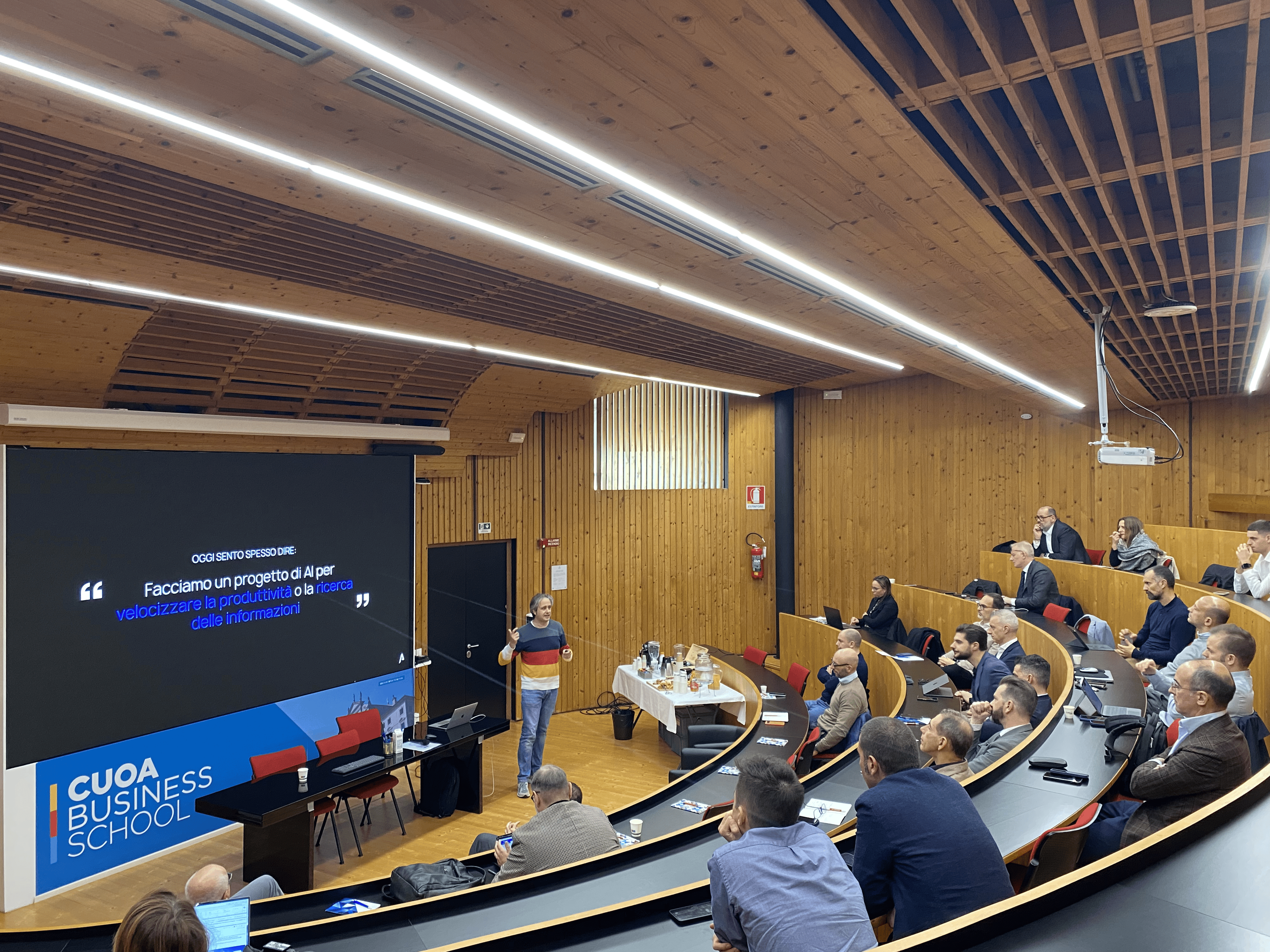 foto della sala con platea e relatore che parla