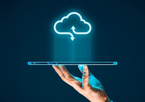 Mano che tiene un tablet con un'icona di cloud computing sospesa sopra