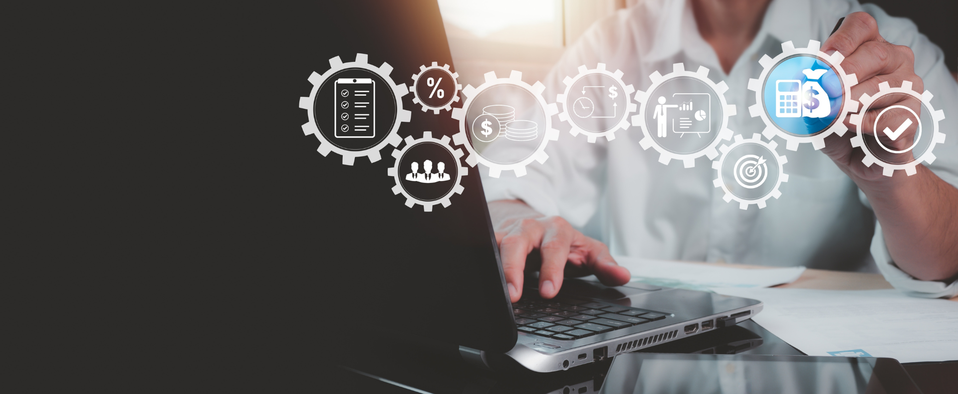 Professionista lavora su laptop con in primo piano icone di ingranaggi dei diversi processi aziendali