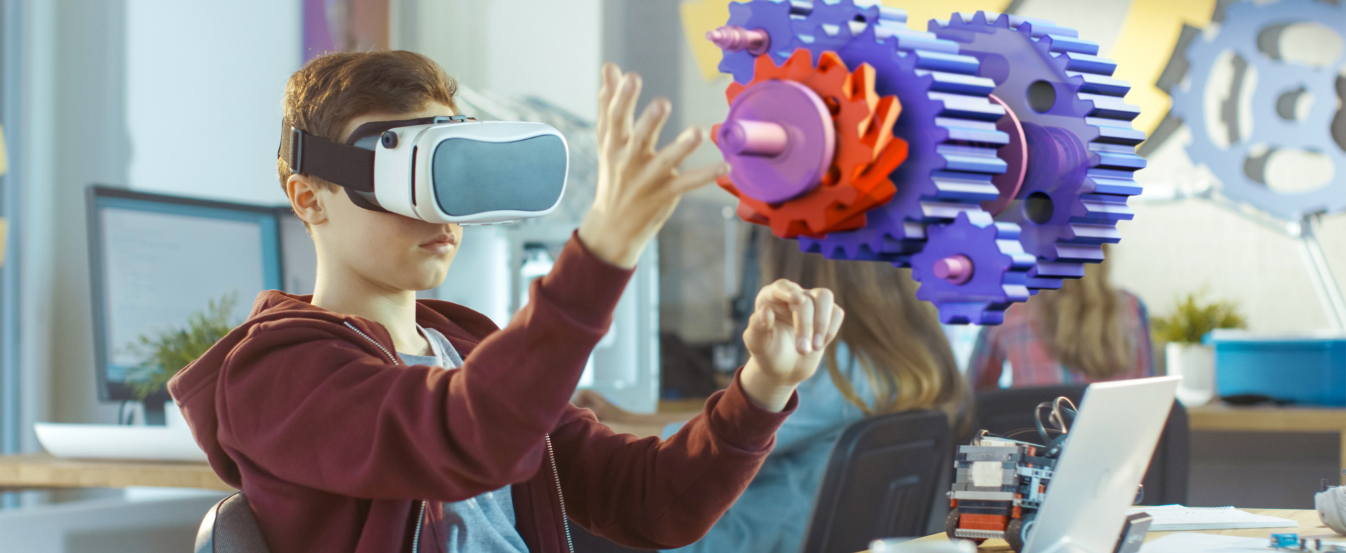 tudente usa un visore VR per interagire con ingranaggi virtuali