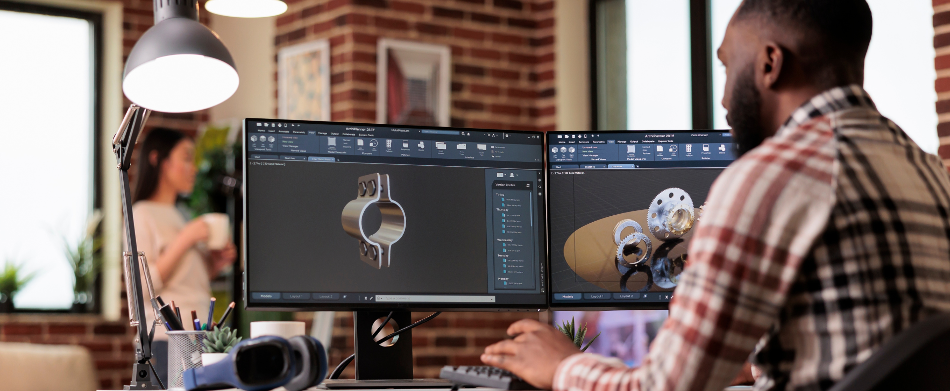 Ingegnere al lavoro su progetti CAD su due monitor in ufficio