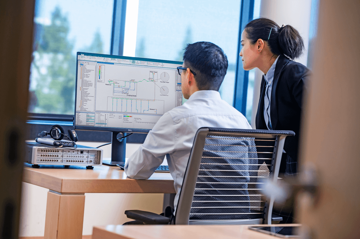 Simulazione di un impianto industriale al computer mentre due progettisti lo analizzano