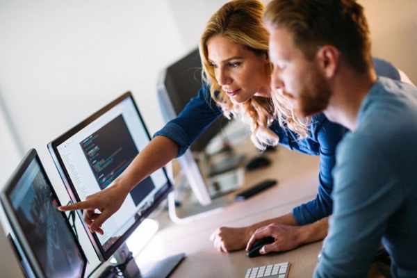 Due professionisti collaborano su un progetto davanti a monitor