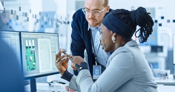 Due ingegneri esaminano un progetto elettronico su un monitor in ufficio