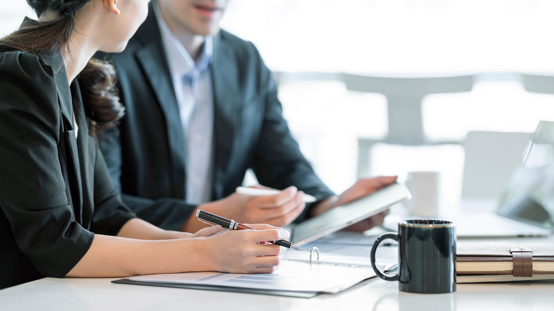 Due colleghi discutono di lavoro durante una riunione