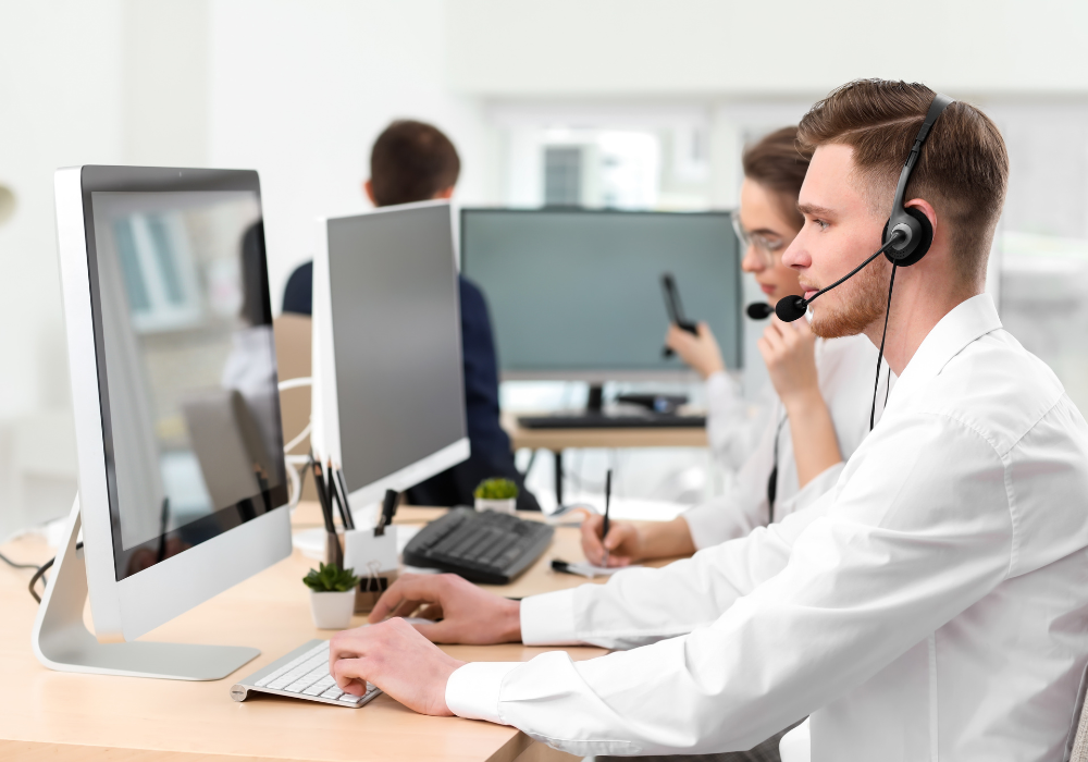 Operatori di call center al lavoro con computer e cuffie