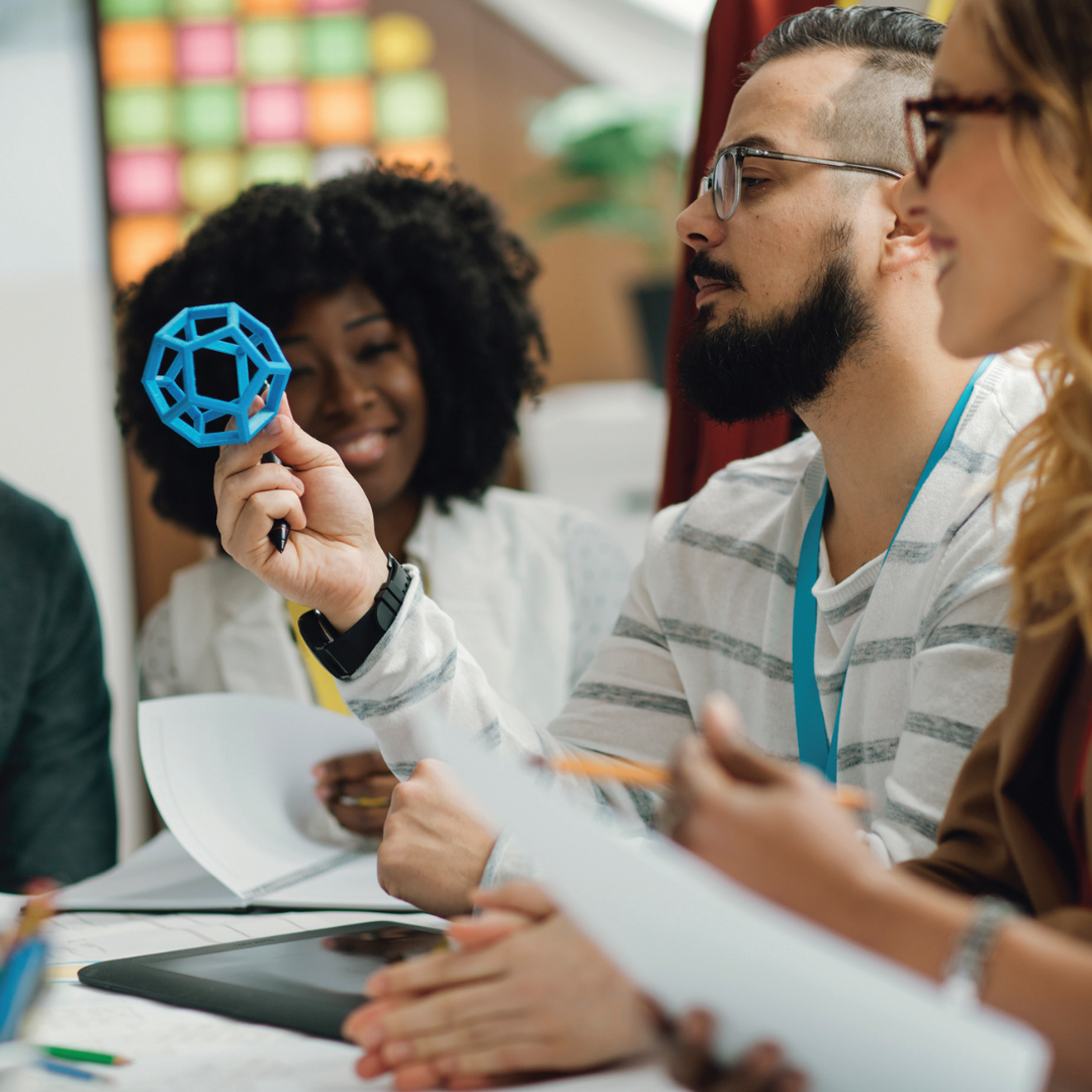 Gruppo di persone che discute di un prototipo in una riunione creativa