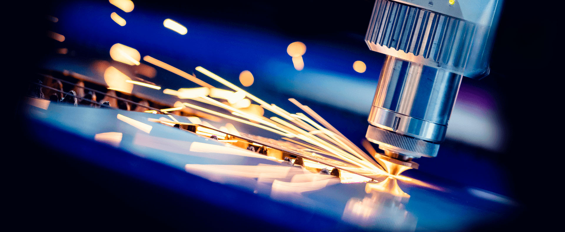 Vista ravvicinata di un taglio laser che incide un pezzo di metallo, creando scintille