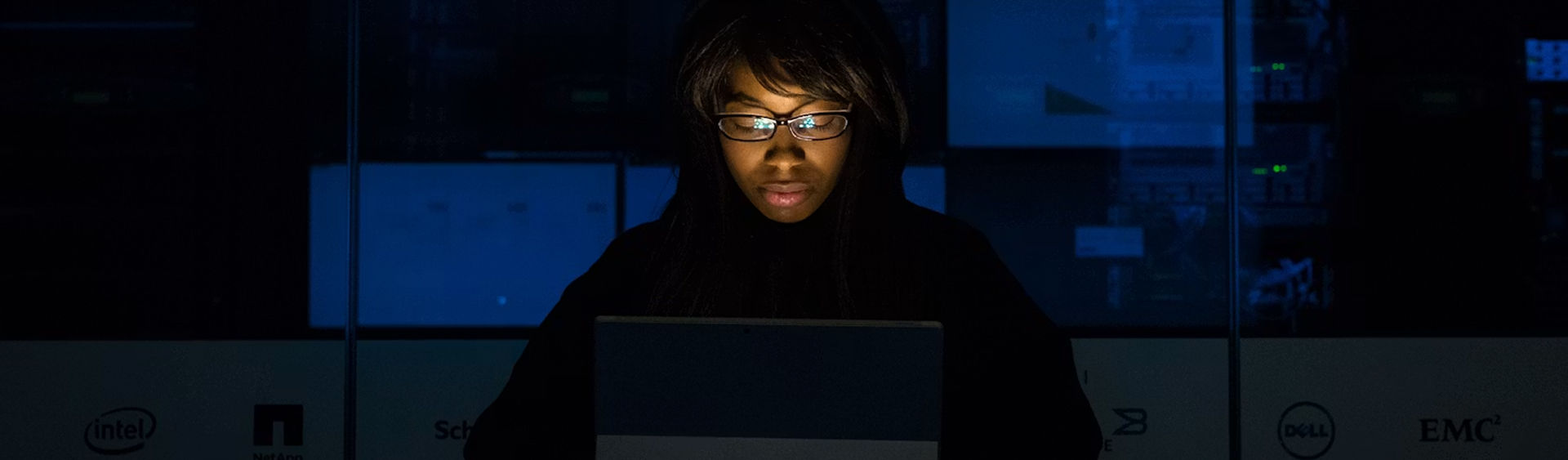 Mujer usando un ordenador portátil a oscuras
